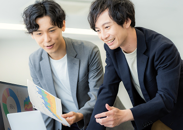 オフィスで資料を見ながら話すビジネスパーソン